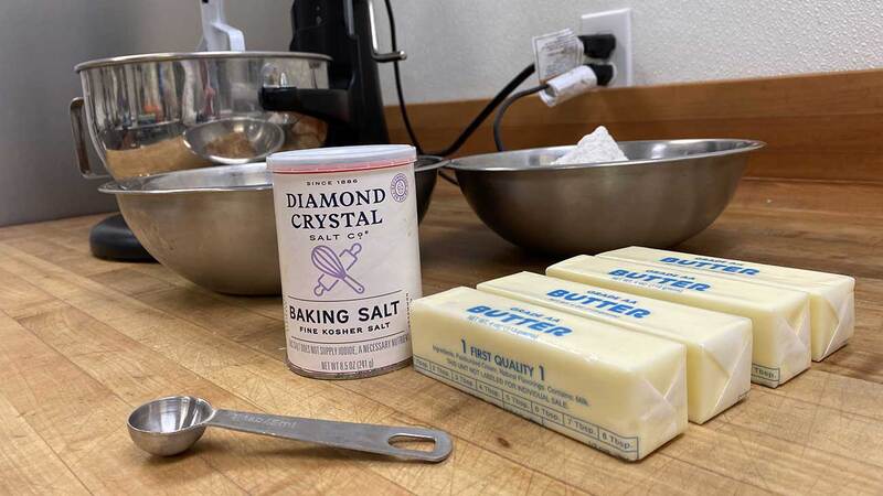 在黄油和碗旁边的桌子上放一容器Diamond Crystal Fine Kosher Baking Salt™。